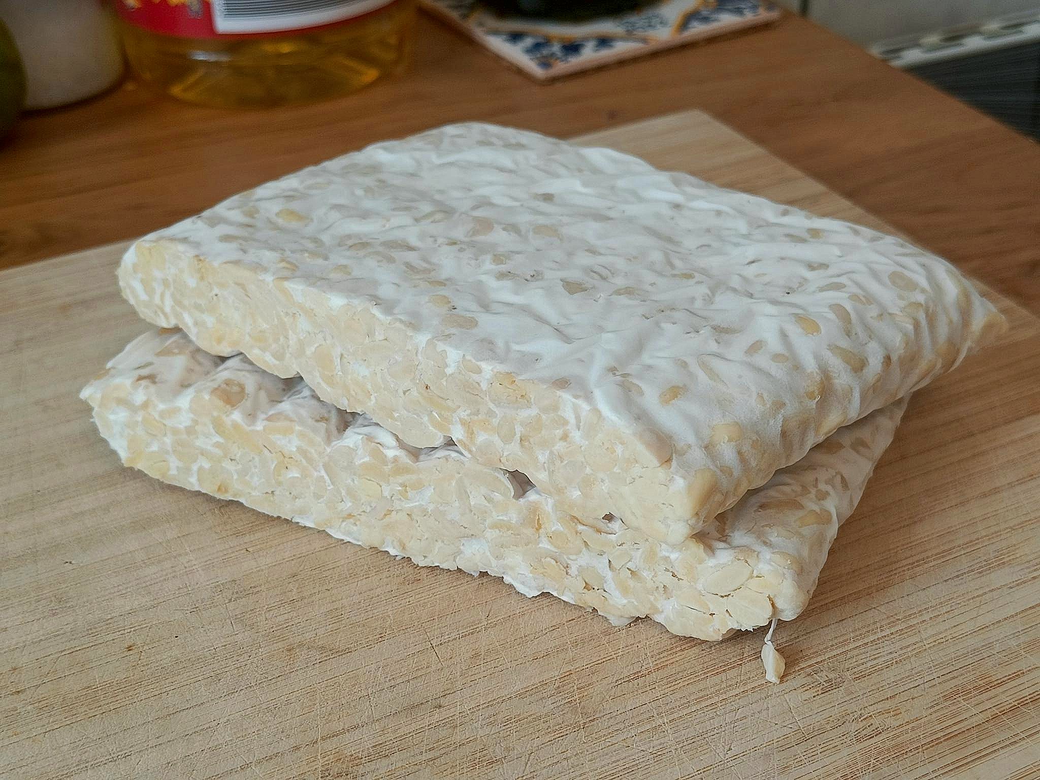 photo of two slabs of my tempeh, pale white mushroom surrounding yellow soybeans